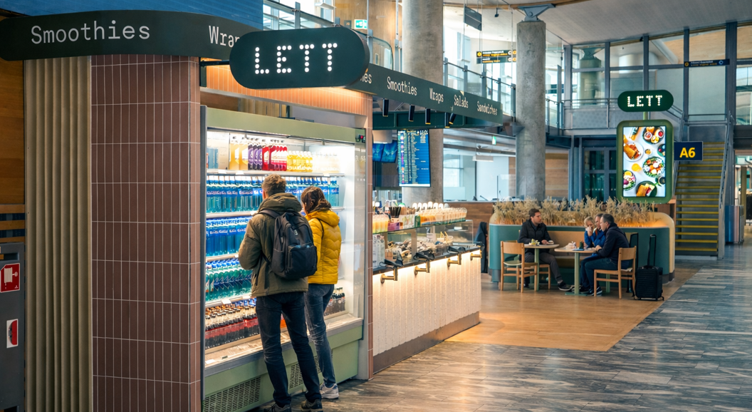 Assorterte sunne boller, wraps og drikkevarer på en lys bakgrunn, med friske grønnsaker, korn og fargerike juice. Ideelt for et næringsrikt måltid
