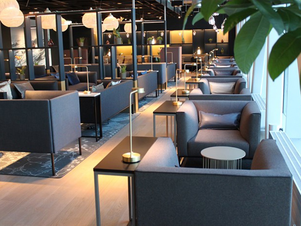 Modern and elegant lounge with comfortable gray sofas, small table lamps, and decorative elements, designed for relaxation and social interaction.