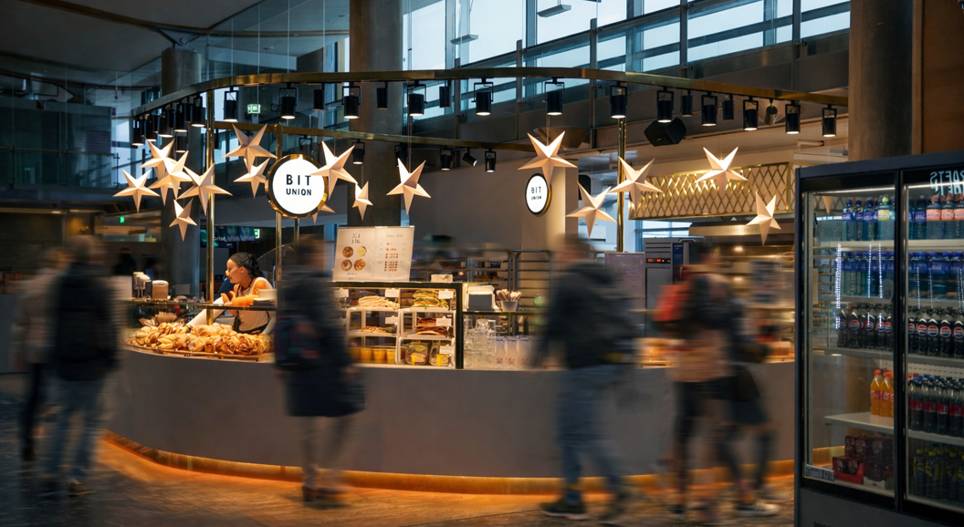 Assorted pastries featuring Danish pastries, buns, and sweet rolls with fruit and custard fillings, topped with powdered sugar, and branded with "BIT UNION" logo