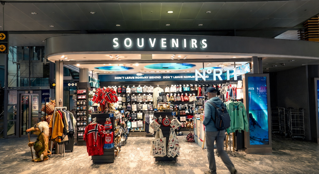 Souvenir shop in Norway featuring traditional Scandinavian apparel, flags, and assorted gifts with prominent signage for "Souvenirs" and "North