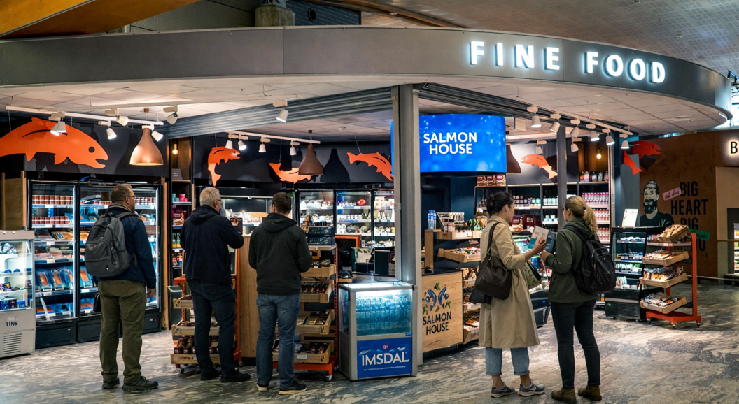 Logo for Salmon House featuring two stylized fish encircled by green leaves and berries, with the text "Salmon House" beneath in bold blue letters