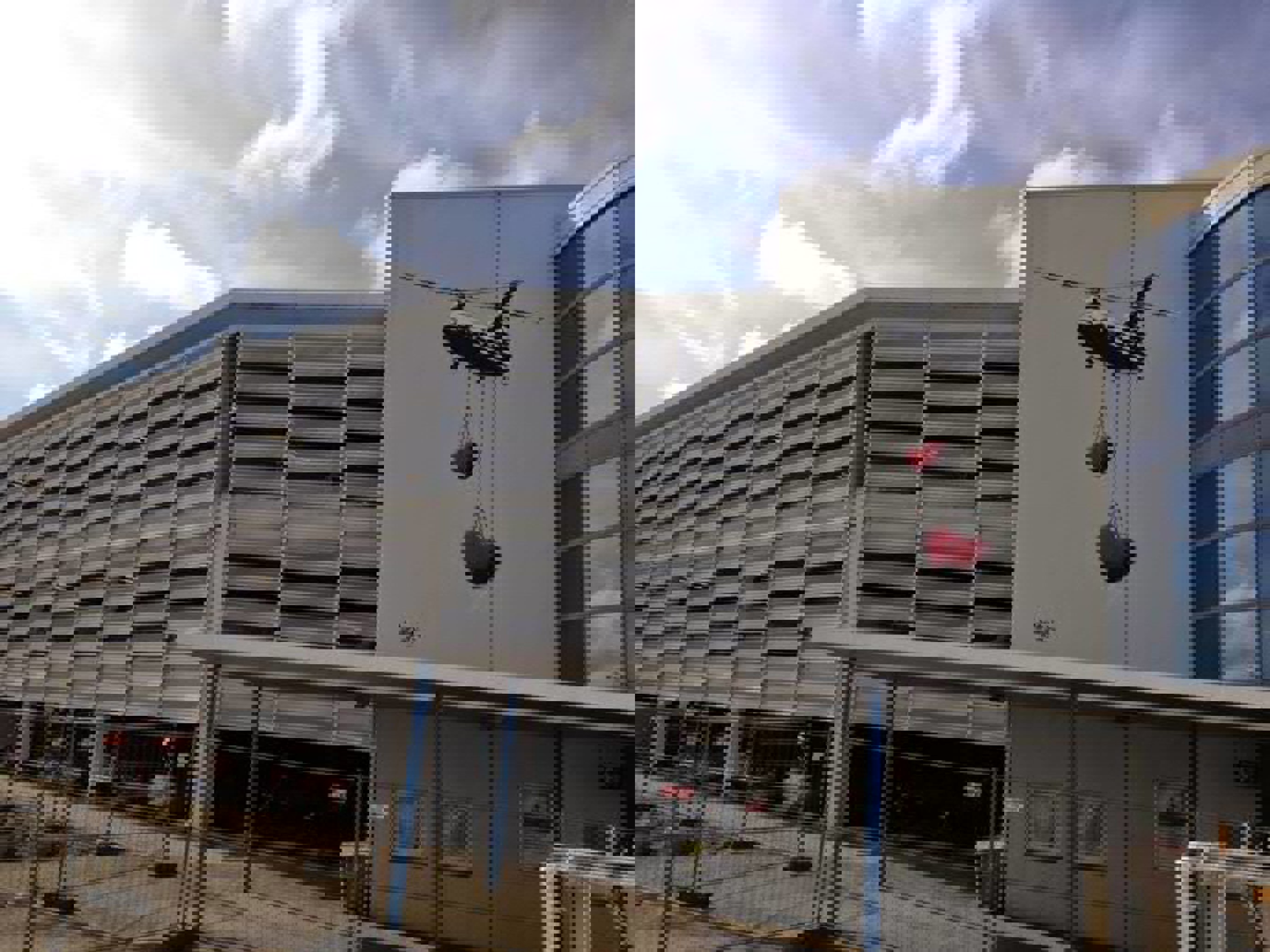 Kunstverk på Stavanger flyplass, maleri utenpå terminalbygget. To hjerter i rødt henger fra et fly