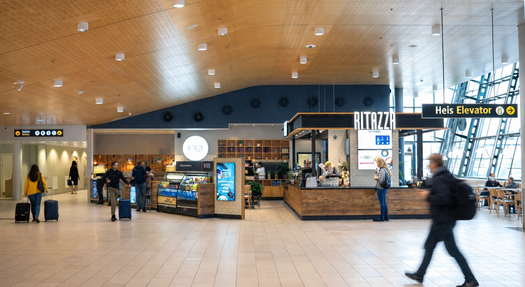 Iskaffe i glasskrus med isbiter på trefat, omgitt av kaffebønner og treskje